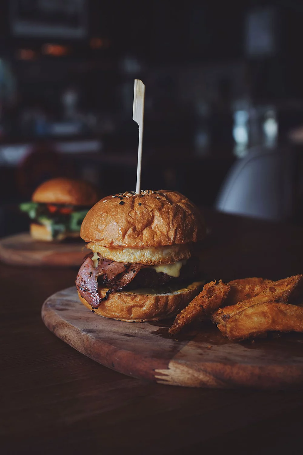 Gourmetburger mit hausgemachten Wedges auf Holzplatte