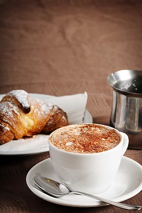 Melange und ein süßes Croissant mit Staubzucker